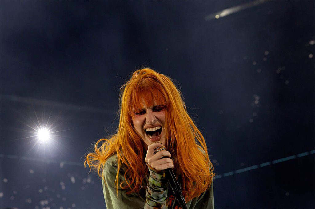 Hayley Williams de Paramore aprovecha un micrófono en el escenario. 