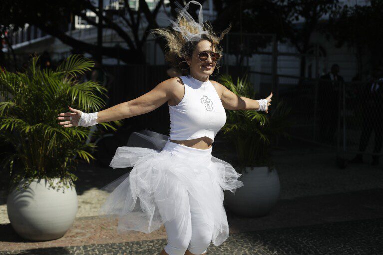 Un fan de Madonna baila afuera del Hotel Copacabana Palace donde se hospeda Madonna antes de su concierto en Río de Janeiro, Brasil, el viernes 3 de mayo de 2024. Madonna concluirá su gira el sábado con un concierto gratuito en la playa de Copacabana.  (Foto AP/Bruna Prado