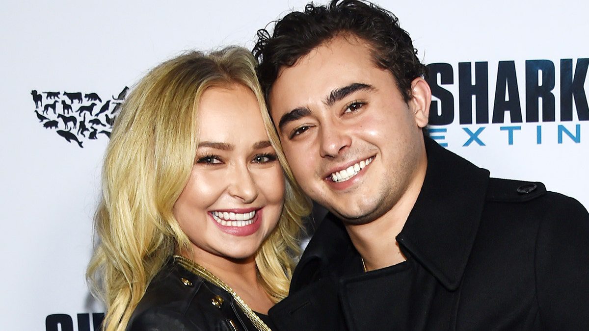 Hayden Panettiere sonríe con una chaqueta negra junto a su hermano Jansen, que también viste de negro en la alfombra roja de Hollywood.