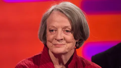 PA Media Dame Maggie Smith usa una chaqueta roja en 2015