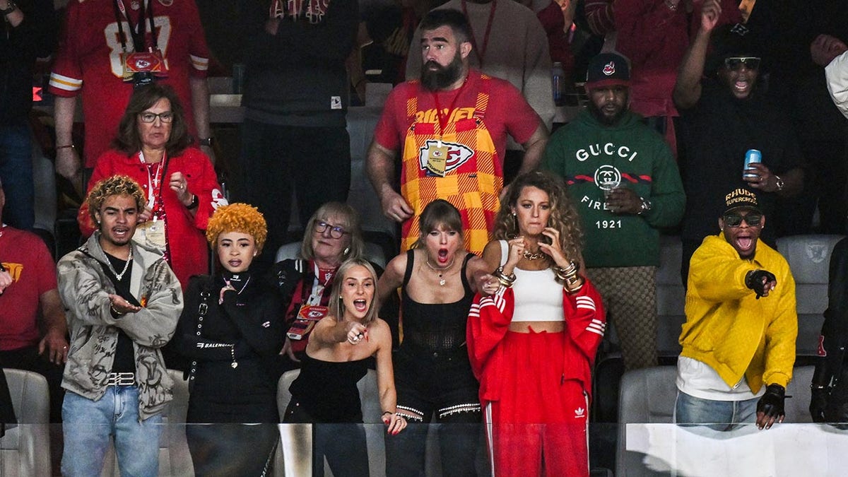 Taylor Swift se viste de negro en una caja con amigos durante el Super Bowl y Jason Kelce está detrás de ella con ropa de los Chiefs.